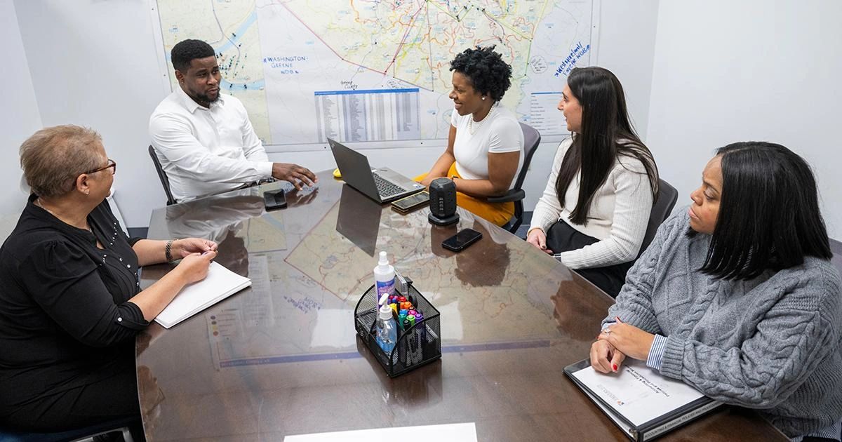 Team meeting with maps on the wall